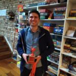 Winner of Azul tournament holding trophy